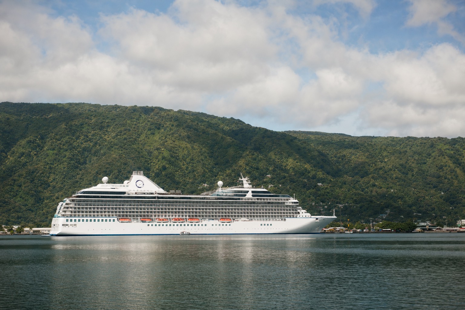 Cruise ship at anchor in Hilo Bay under morning light with green Hamakua slopes behind