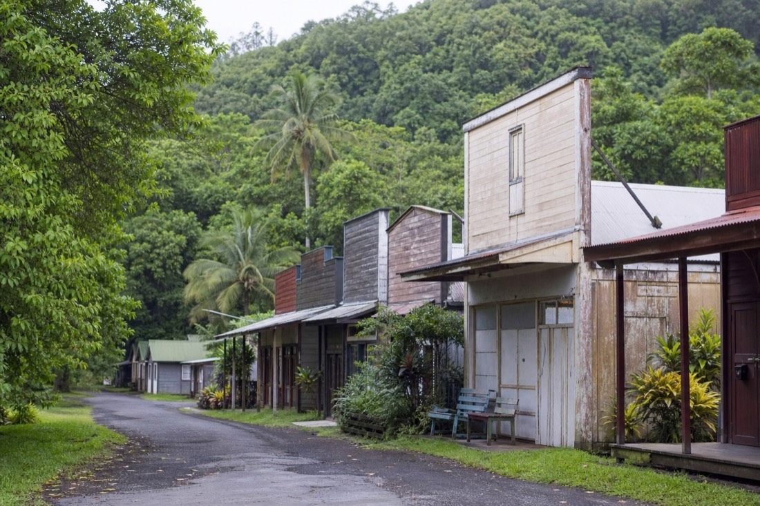 Weathered plantation-era wooden storefronts with false fronts along the main street of Honomu
