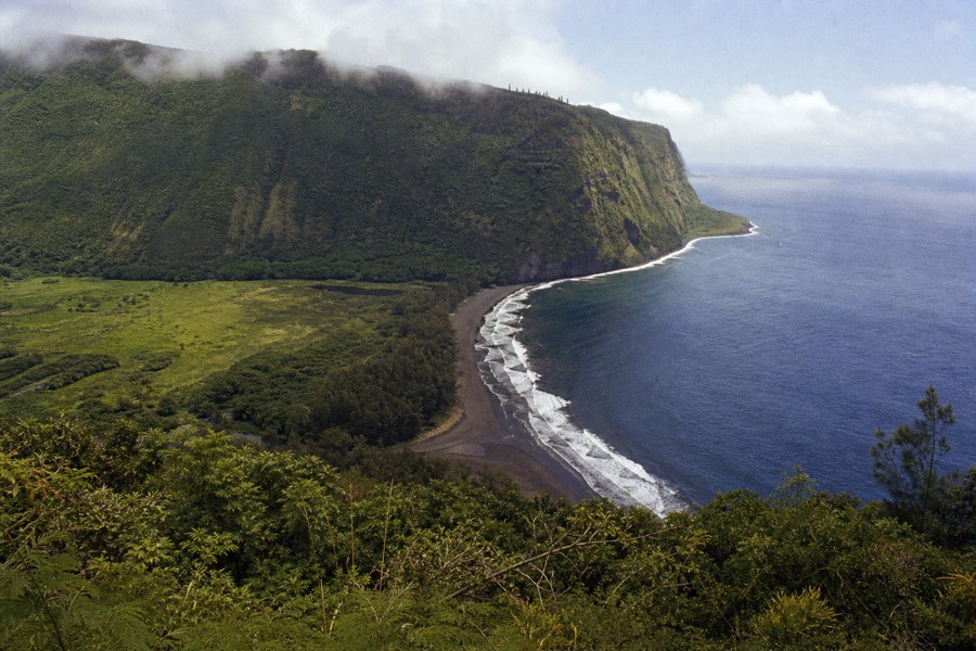 Waipio Valley lookout view of green cliffs meeting the sea